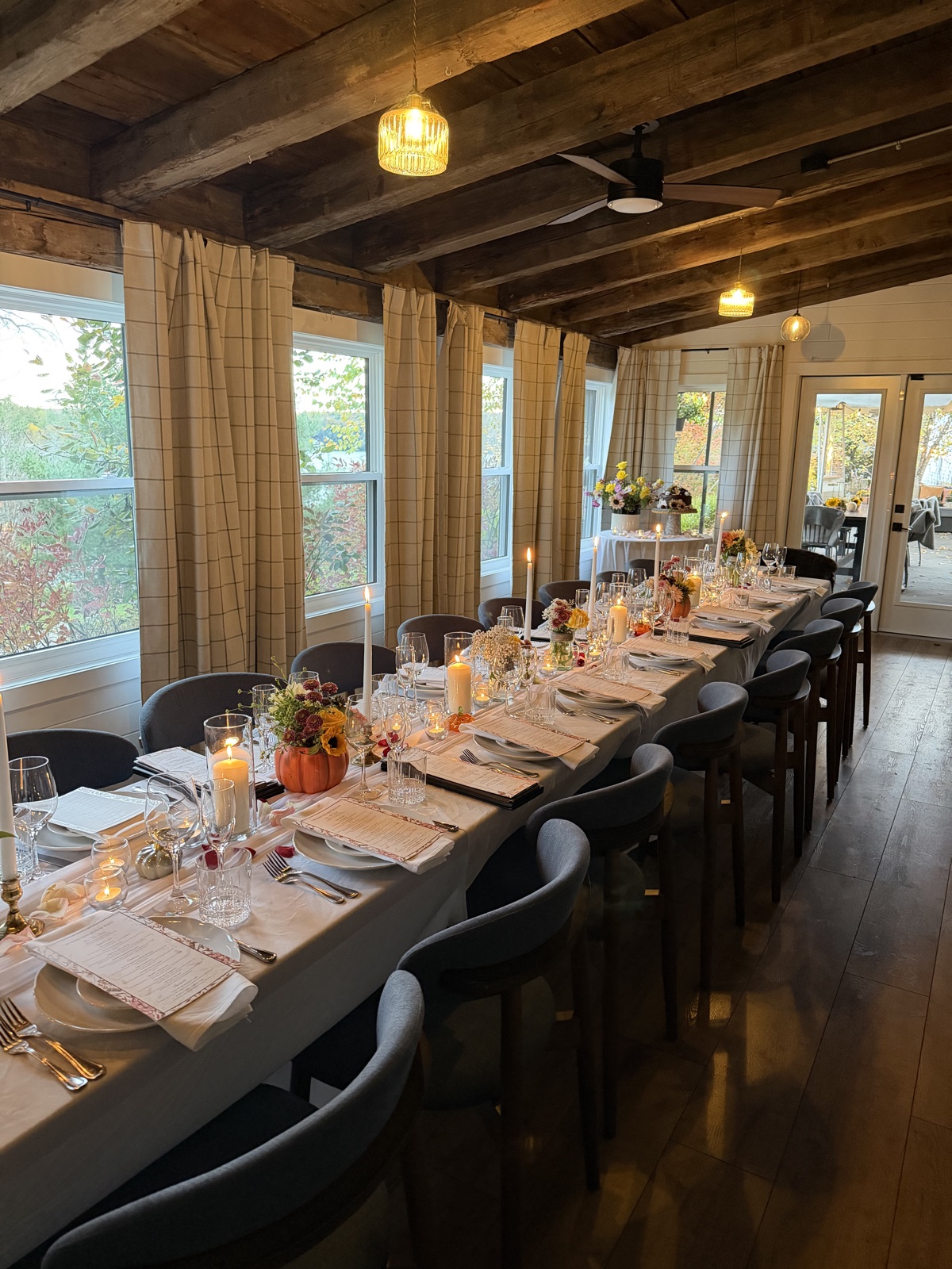 Private room long table set for a group dinner at Crossroads, with candles and fall florals