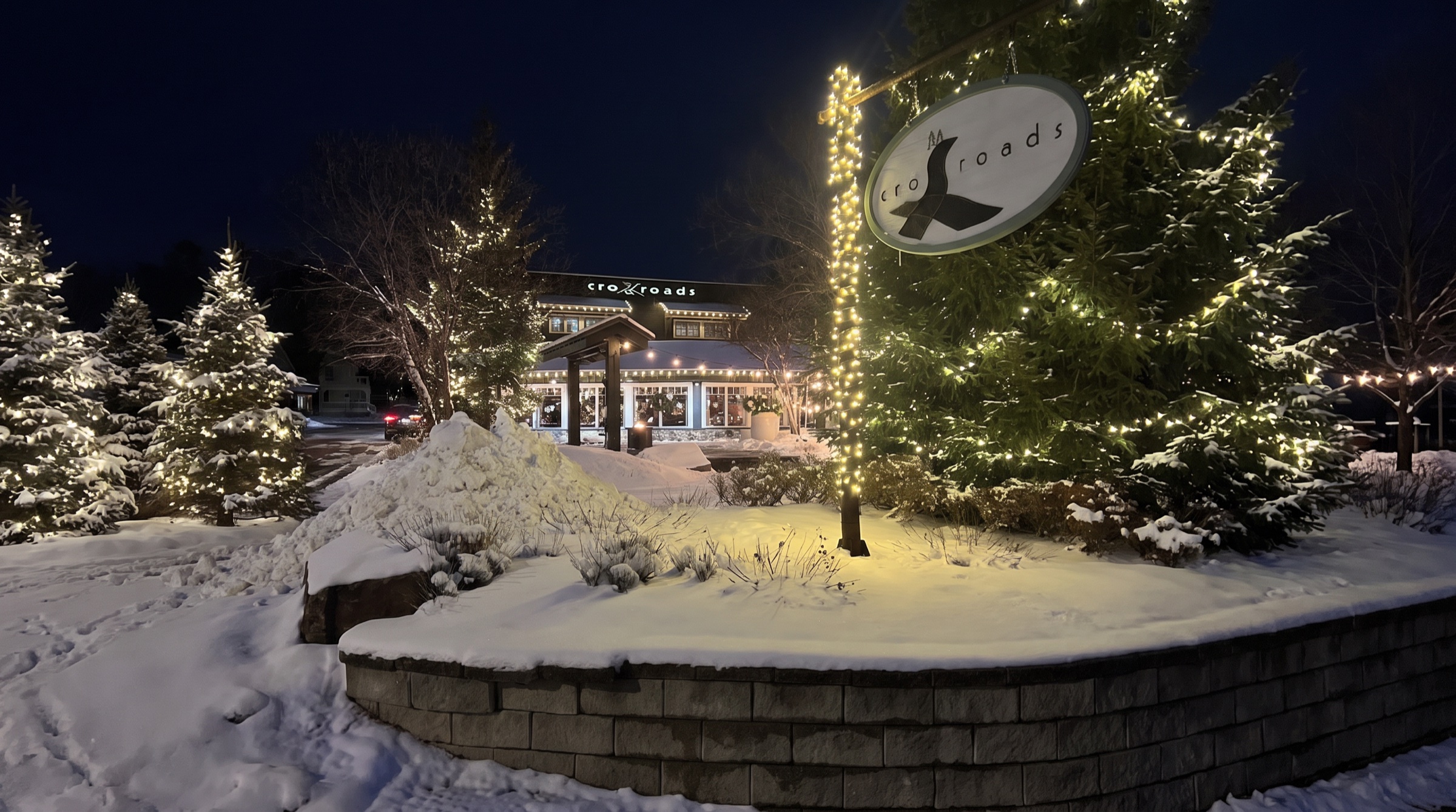 Crossroads restaurant on a snowy winter evening in Rosseau, lit with holiday lights